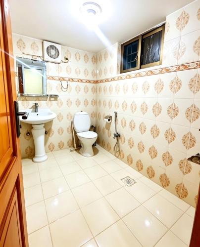 a bathroom with a toilet and a sink at The Eastern Lodge in Islamabad