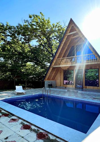 a house with a swimming pool with a roof at Qafqaz A-Frame Chalet Gabala in Gabala
