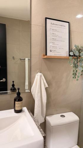 a bathroom with a sink and a toilet and a mirror at studio MA-DE cozy Bacolod City in Bacolod