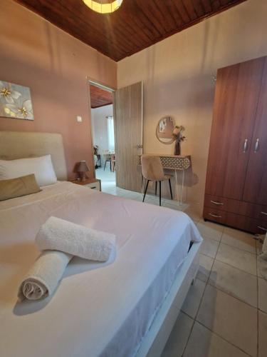 a bedroom with a white bed with towels on it at Peter's Village in Kalamaki Messinia