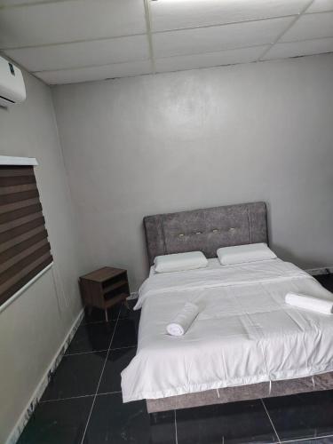 a bedroom with a large bed with white sheets at GP StayIn in Lunas
