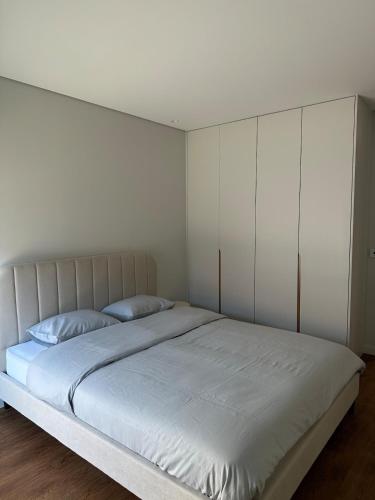 a bedroom with a large bed with white walls at Premium T1 - Golden Sunset in Espinho