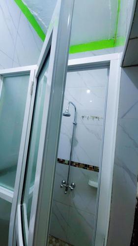 a glass shower door in a bathroom at Zone hotel and guest house in Bugembe