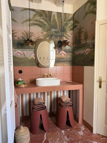 a bathroom with a sink and a mirror and stools at Maison Romy in Chinon