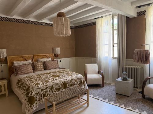 a bedroom with a bed and a chair at Maison Romy in Chinon