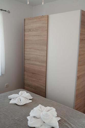two towels sitting on a bed in front of a mirror at EUCALYPTUS in Nerezine