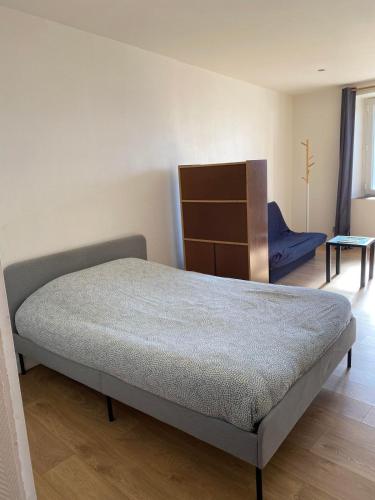 a bedroom with a bed and a blue chair at studio in Saint-Pourçain-sur-Sioule