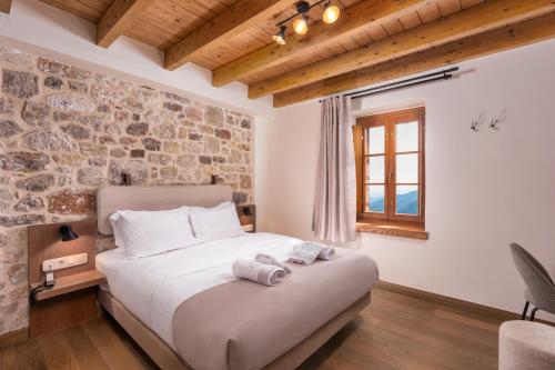 a bedroom with a bed with two towels on it at Μikri Arktos Boutique Hotel in Dimitsana