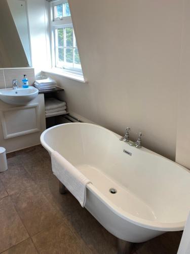 a white bath tub in a bathroom with a sink at Lysses House Hotel in Fareham