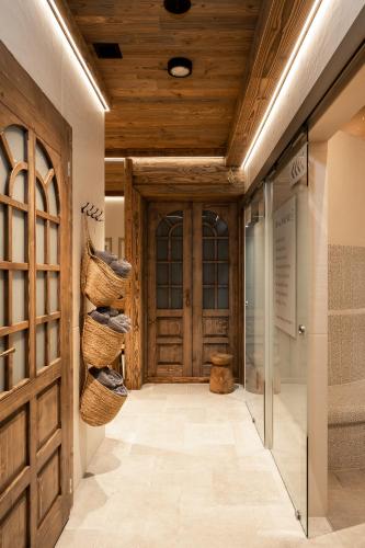 a hallway with a large wooden door and baskets at W Dolinie Tylicza SPA & Wellness -gabinet masażu, saunarium-plac zabaw, rowery elektryczne, animacje dla dzieci in Krynica Zdrój