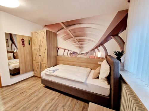 a bedroom with a bed in a room with a ceiling at Hotel Kanta in Kappel-Grafenhausen