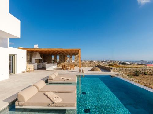 a villa with a swimming pool and a house at Vendema Residence Mykonos in Mikonos