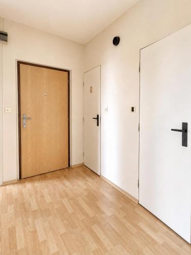 an empty room with a door and a wooden floor at Apartman Anna in Závada