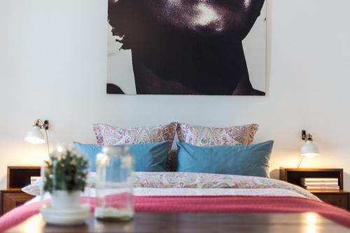 a bedroom with a bed with a table and a picture at House Sao Bento in Lisbon