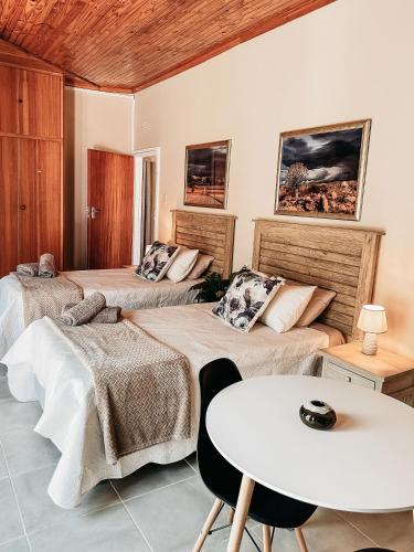 a room with two beds and a table at Lekkerbly Self Catering in Pofadder