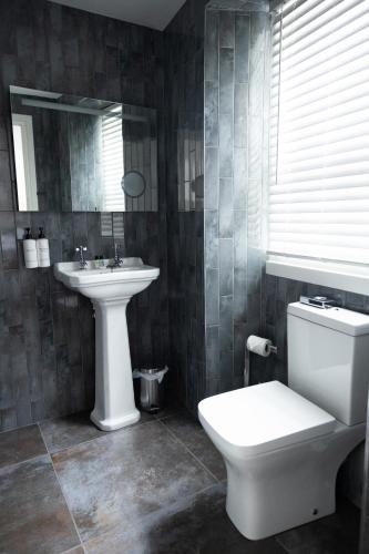 a bathroom with a white toilet and a sink at Allerdale Court Hotel in Cockermouth