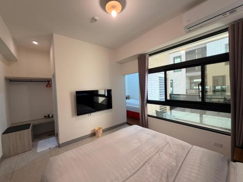 a bedroom with a large bed and a large window at 111 Gukeng Homestay in Gukeng
