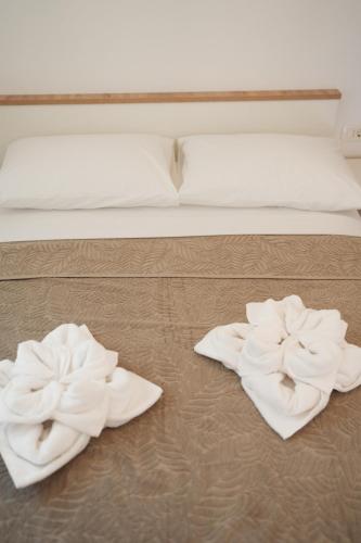 two towels are sitting on the floor next to a bed at LAVANDLA in Nerezine