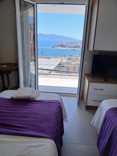 a room with two beds and a large window at Sea & Relax Villa in Sarandë