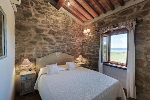 ein Schlafzimmer mit einem großen Bett und einem Fenster in der Unterkunft Agriturismo Antico Corniolo - Gradoli - Lago di Bolsena in Gradoli