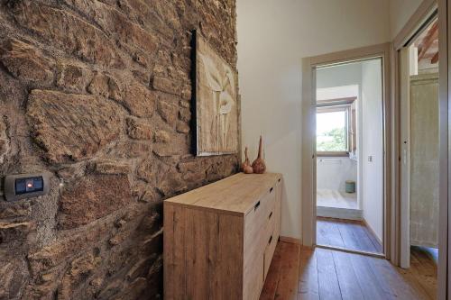 ein Zimmer mit einer Steinwand und einem Holzschrank in der Unterkunft Agriturismo Antico Corniolo - Gradoli - Lago di Bolsena in Gradoli