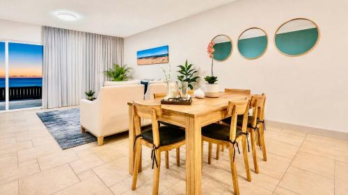 a dining room with a table and a couch at 2 at Sunset View in Langstrand