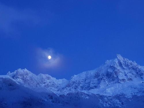 a moon over a snow covered mountain at night at Alpenrose Chamonix in Chamonix