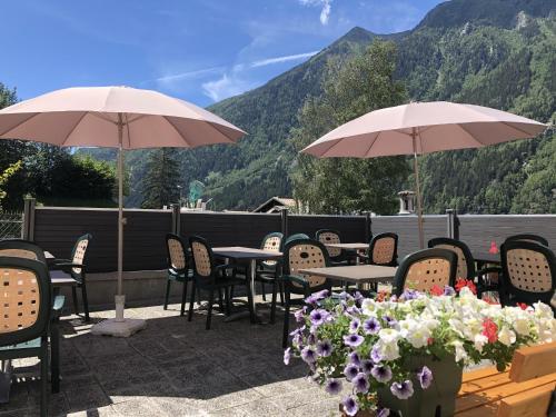 a patio with tables and chairs and umbrellas at Alpenrose Chamonix in Chamonix