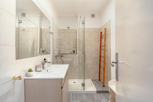 a white bathroom with a sink and a shower at Santarem Terrace by Homing in Santarém