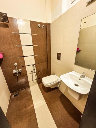 a bathroom with a sink and a toilet and a shower at Grand Retreat in Trichūr