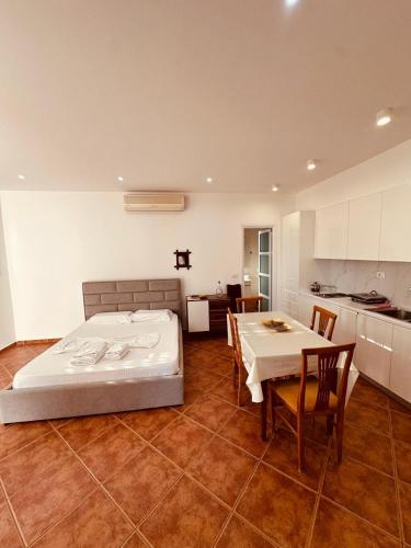 a bedroom with a bed and a table and a kitchen at Vila Rexhepaj in Vlorë