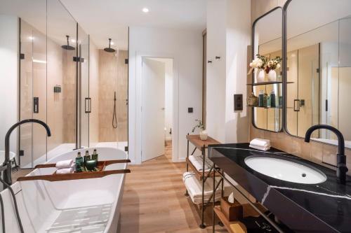 a bathroom with a large sink and a tub at Meliá Granada in Granada