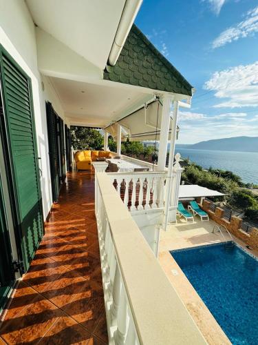 a house with a swimming pool next to the ocean at Vila Rexhepaj in Vlorë