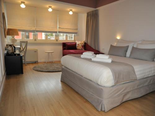 a bedroom with a large bed and a red chair at Its Kale Boutique Hotel in Ioannina