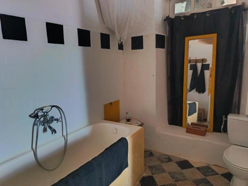 a bathroom with a bath tub and a toilet at La Maison des Artistes in Essaouira