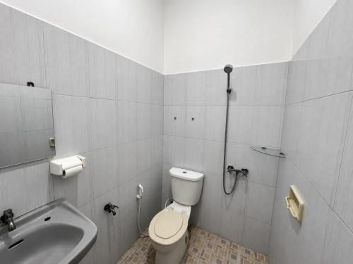 a bathroom with a toilet and a sink at Bawangan Express in Ngadisari