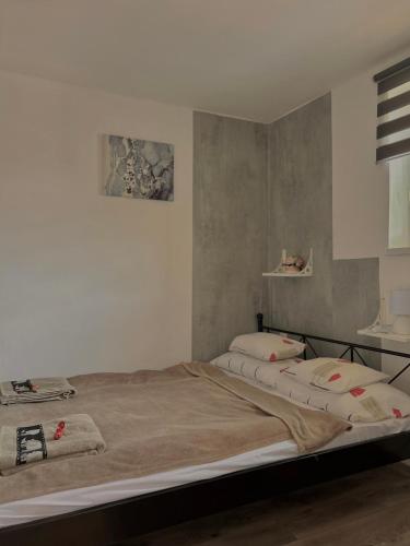 a bedroom with a large bed with two pillows at Gém Home Vendégház in Bodony