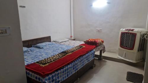 a bedroom with a bed and an air conditioner at Braj Pushp Guest House in Mathura