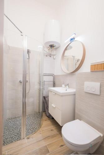 a bathroom with a shower and a toilet and a sink at Corso Apartman in Siófok