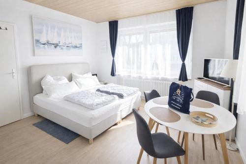 a bedroom with a bed and a table and chairs at Haus Sternenstrand Tossens in Tossens