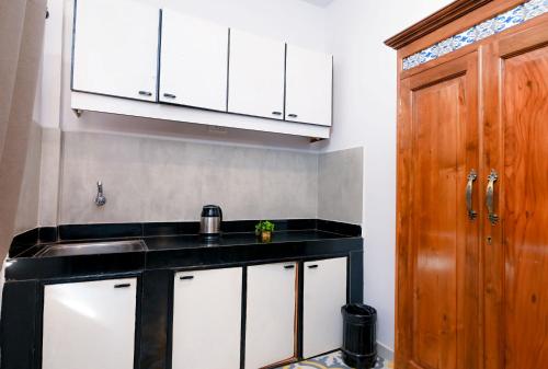 a kitchen with a sink and a wooden cabinet at Joystays Renton Manor in Arpora