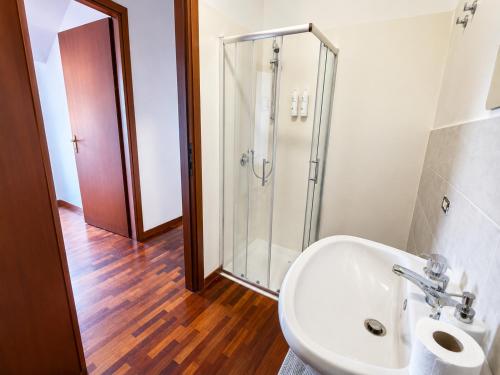 a bathroom with a sink and a glass shower at Emilia's Lakeview Terrace in Brienno