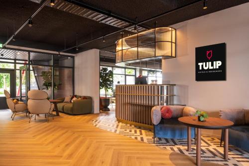 a lobby with couches and chairs and a table at TULIP Hotels & Residences - Zwolle in Zwolle