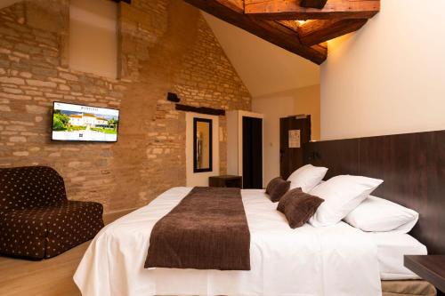 a bedroom with a large white bed and a chair at Château Du Mont Joly in Sampans