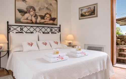a bedroom with a white bed with towels on it at Amazing Two-Bedroom House with Sea View in Cala di Volpe in Porto Cervo