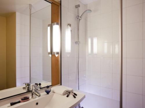 a bathroom with a shower and a sink and a mirror at Ibis Provins in Provins