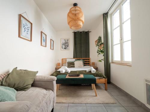a living room with a couch and a bed at Le Pont Ravet in Bernay