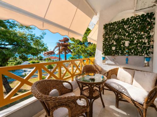 a balcony with a table and chairs and a window at Apartment Dolphin Sea View and First Line in Hanioti