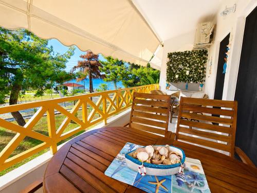 a table with a bowl of food on a balcony at Apartment Dolphin Sea View and First Line in Hanioti