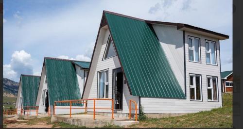 a row of houses with green roofs at Terelj Khangai Resort in Belen Hüryee Hiid